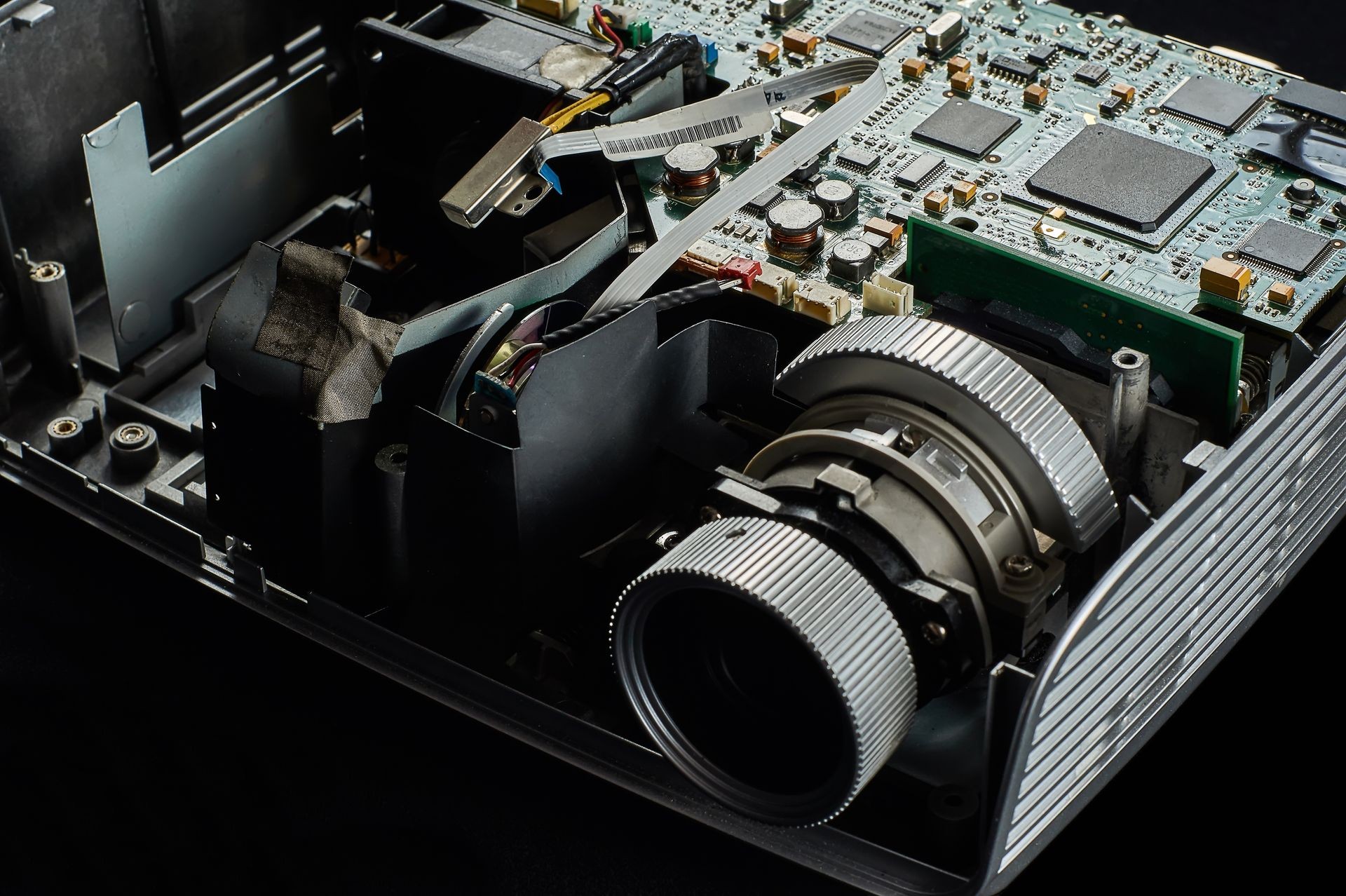 disassembled DLP projector on a black velvet background, front view